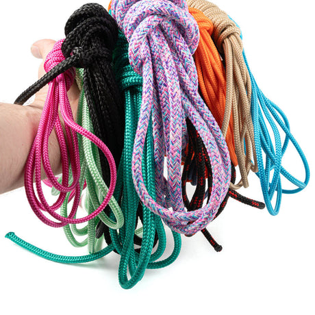 Hand met bundel van 10 hoogwaardige PPMF en polyester touwen in 10 verschillende kleuren en patronen, inclusief wit en zwart. Elk touw is 5 meter lang, met diktes van 4 mm tot 10 mm. Mix van hol touw en touw met kern, sommige unieke uitvoeringen niet los verkrijgbaar. Kleuren zoals roze, groen, blauw, oranje en beige, ideaal voor knutselen, outdoor en decoratie.